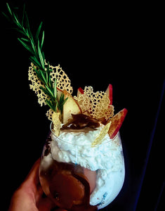 Exquisite ice cream in a glass with whipped cream, apple slices, crisp garnish and a sprig of rosemary